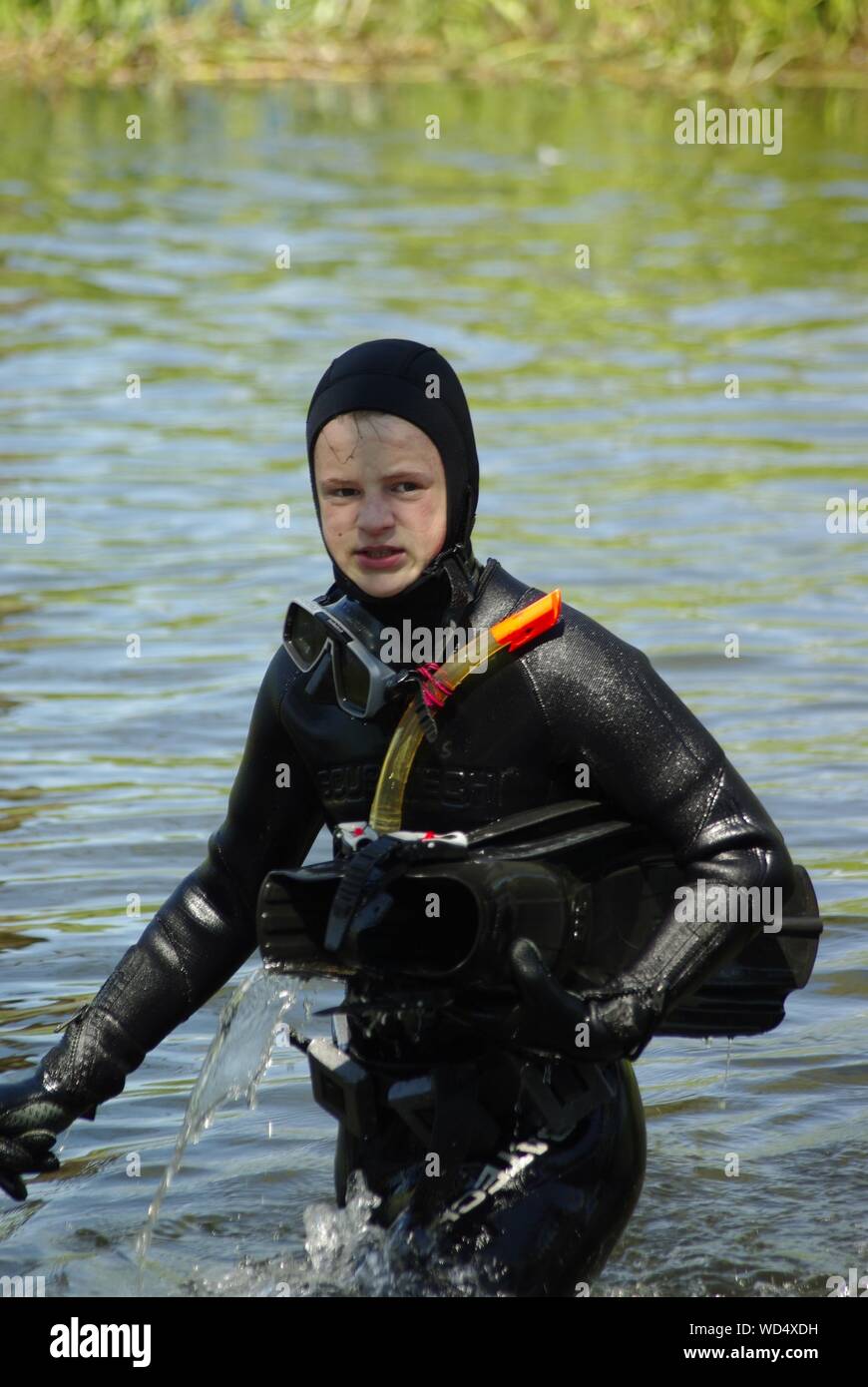 Man Wearing Wetsuit Holding Diving Flippers In Lake Stock Photo Alamy