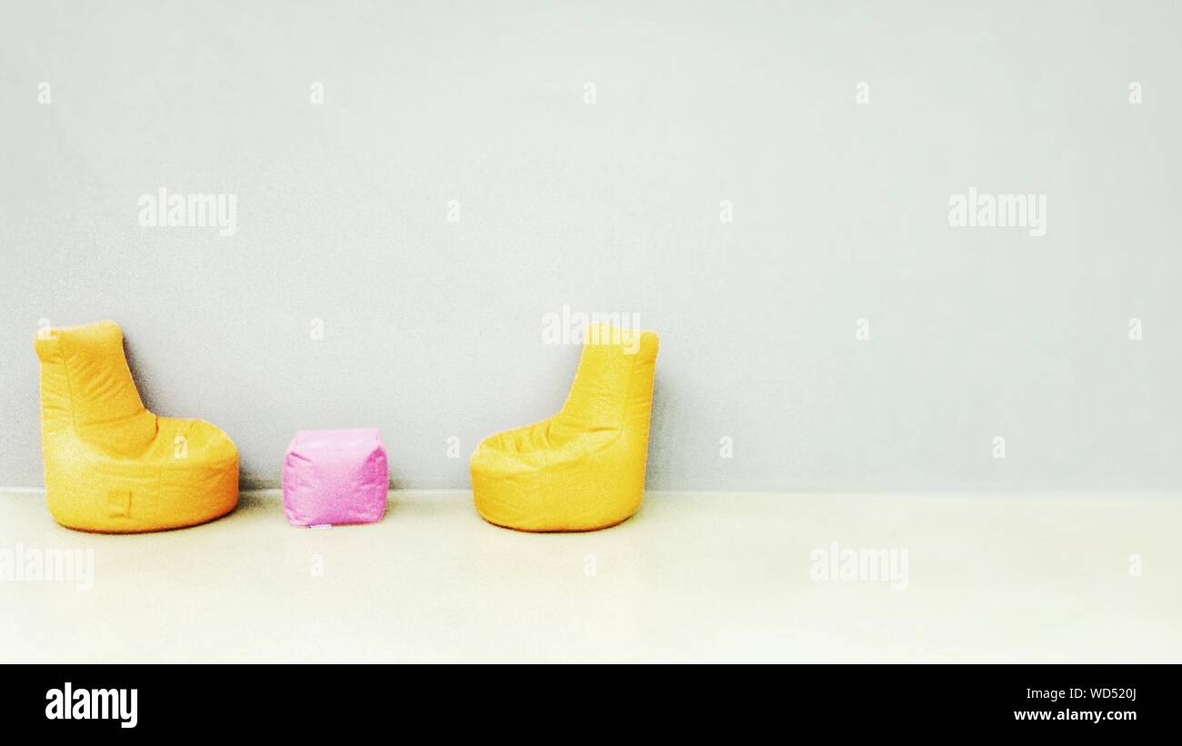 Yellow Bean Bags Arranged Against Wall Stock Photo