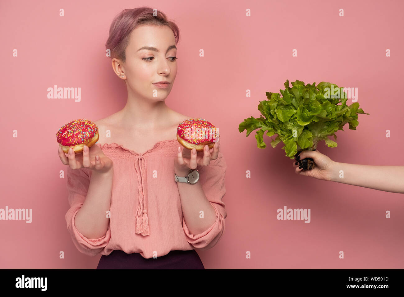 A Girl With Short Hair Holds Donuts In Her Hands And Raising An