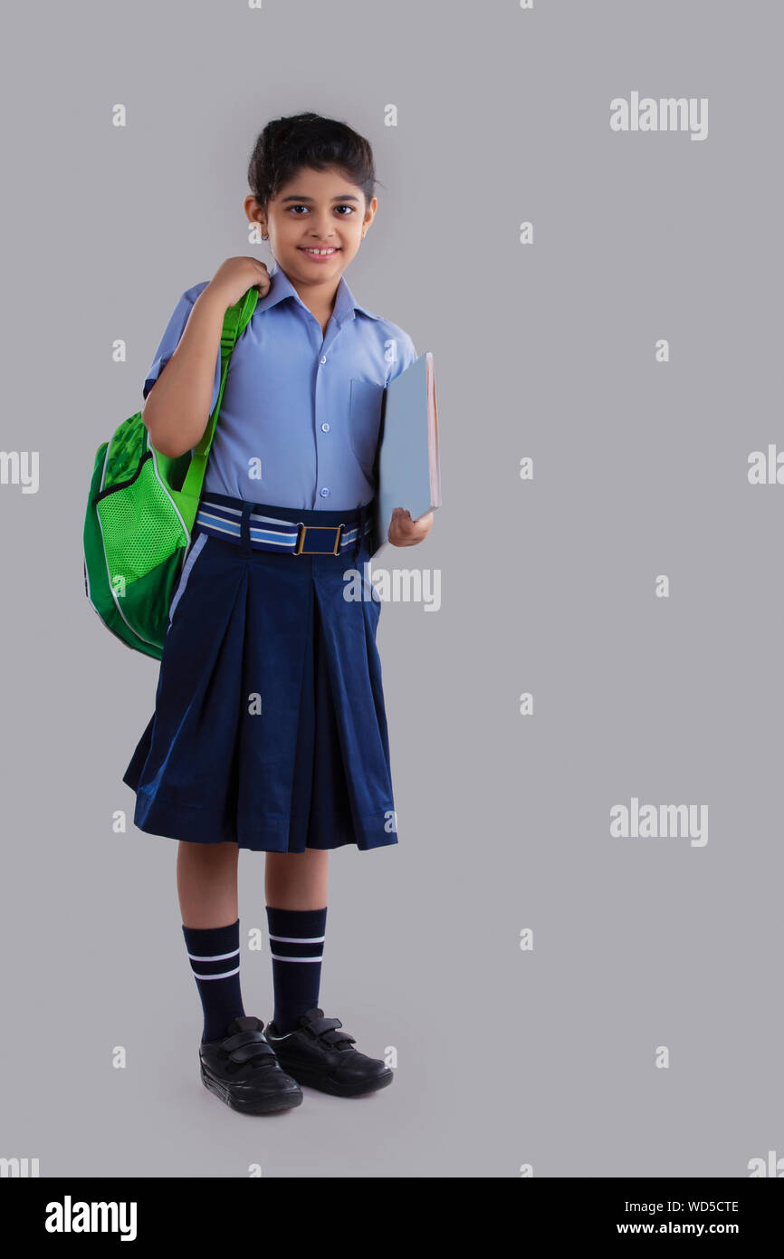 portrait of a school girl holding bag and books smiling Stock Photo - Alamy