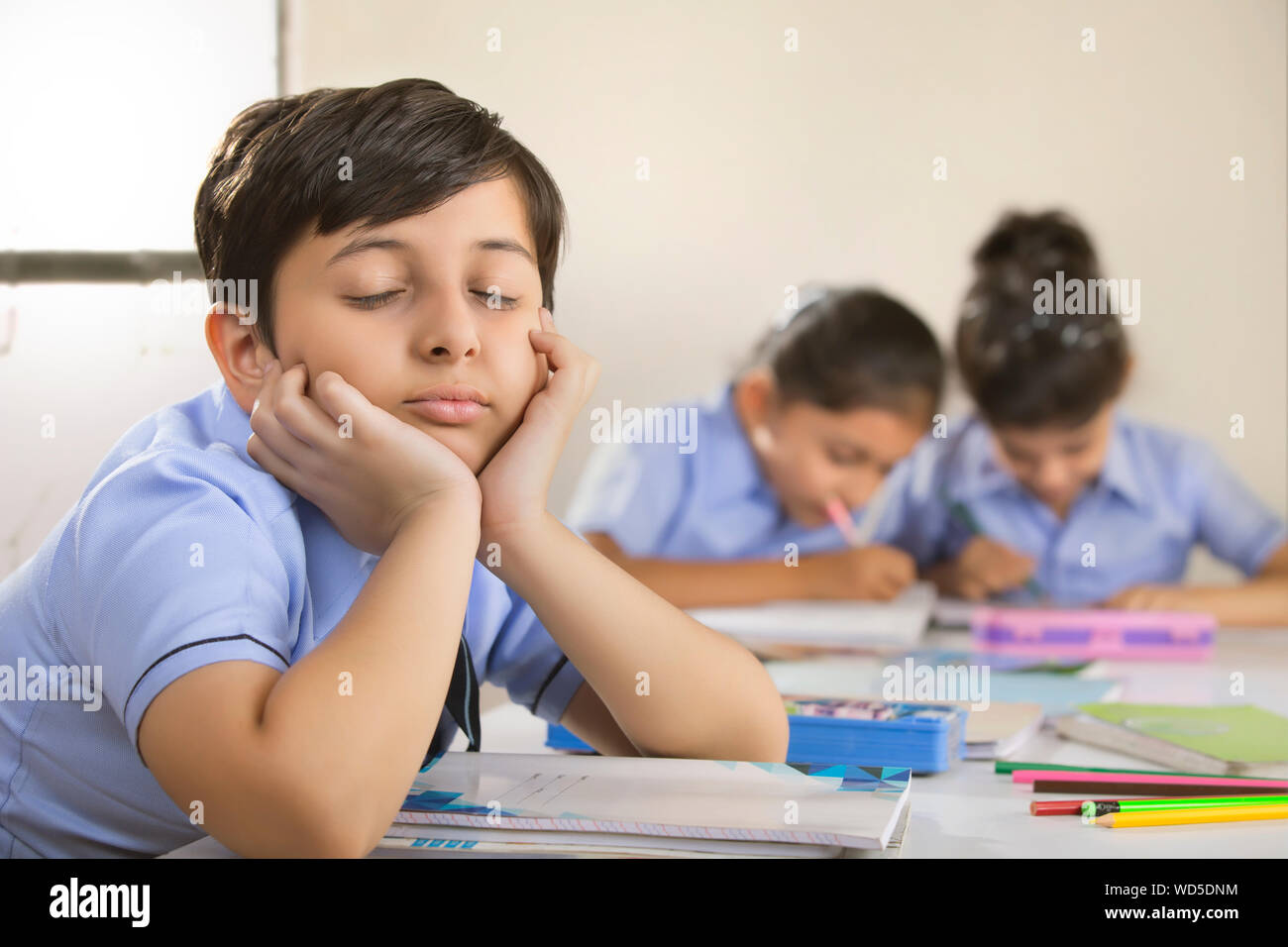 school boy sitting with eyes closed in class Stock Photo