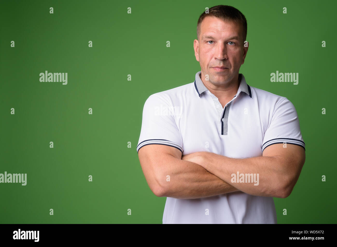 Portrait of macho mature man with arms crossed Stock Photo - Alamy