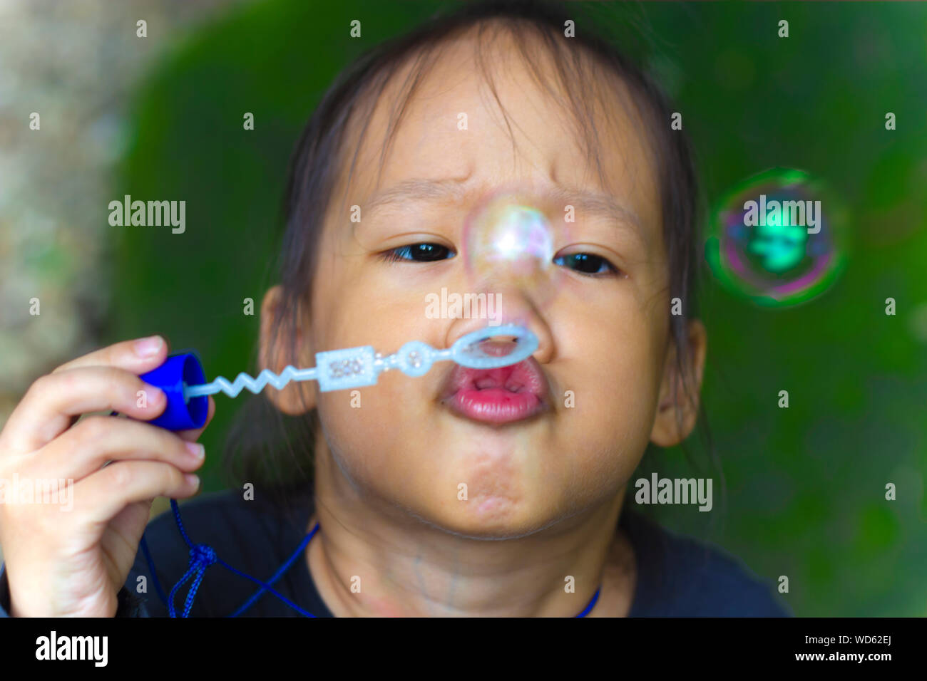 Asian little boy is blowing a soap bubbles, Outdoor Portrait Stock Photo