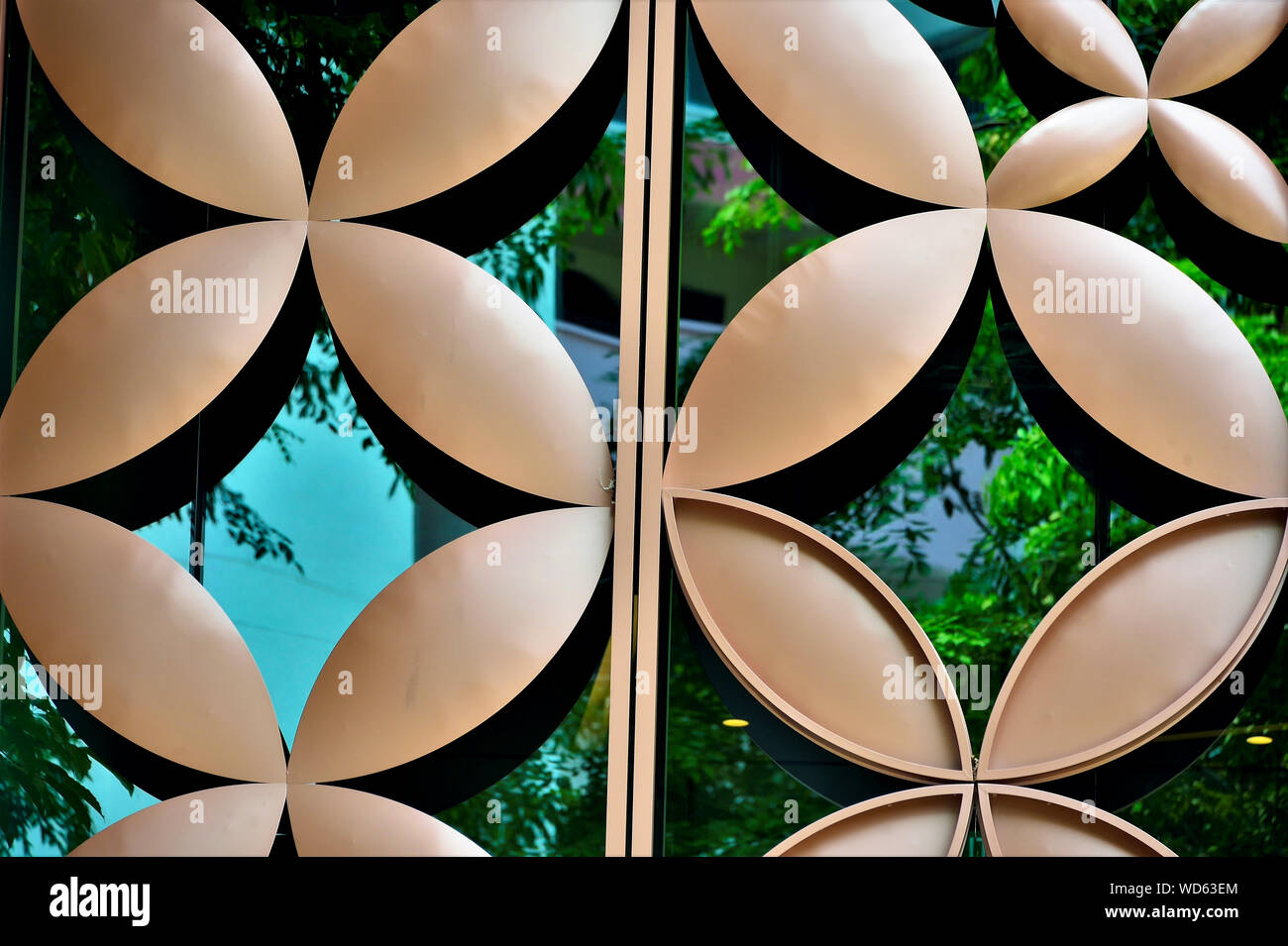 Close up of metal cladding over glass exterior with repeat floral geometric patterns and strong detail as abstract background Stock Photo