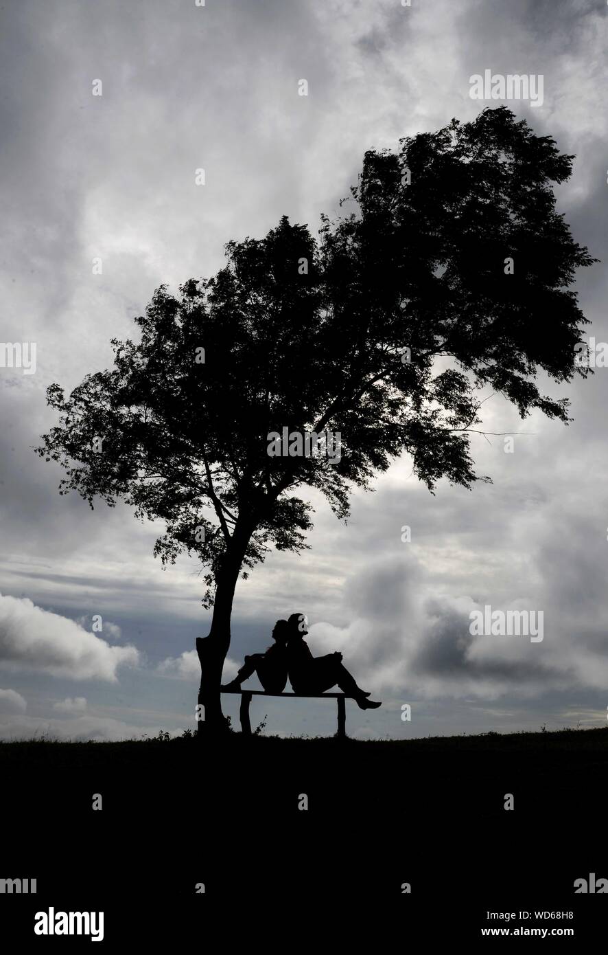Silhouette couple sitting on bench hi-res stock photography and images ...