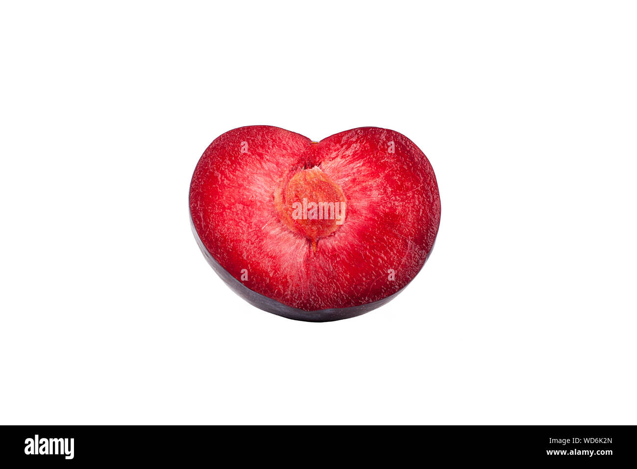 Half plum in the shape of a heart red inside with a stone on a white background isolated close up Stock Photo