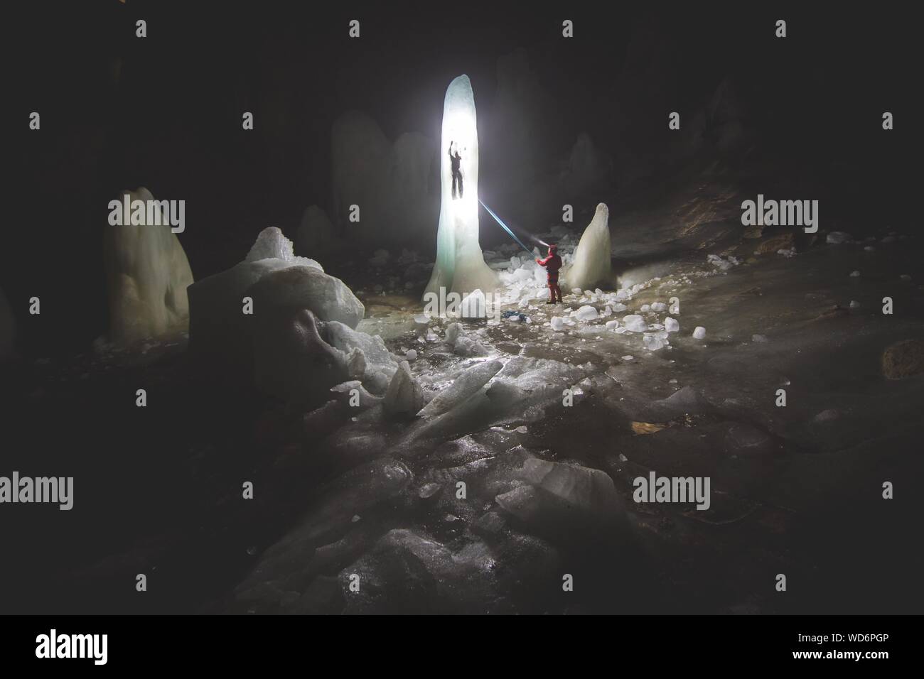 Explorers In Ice Cave Stock Photo