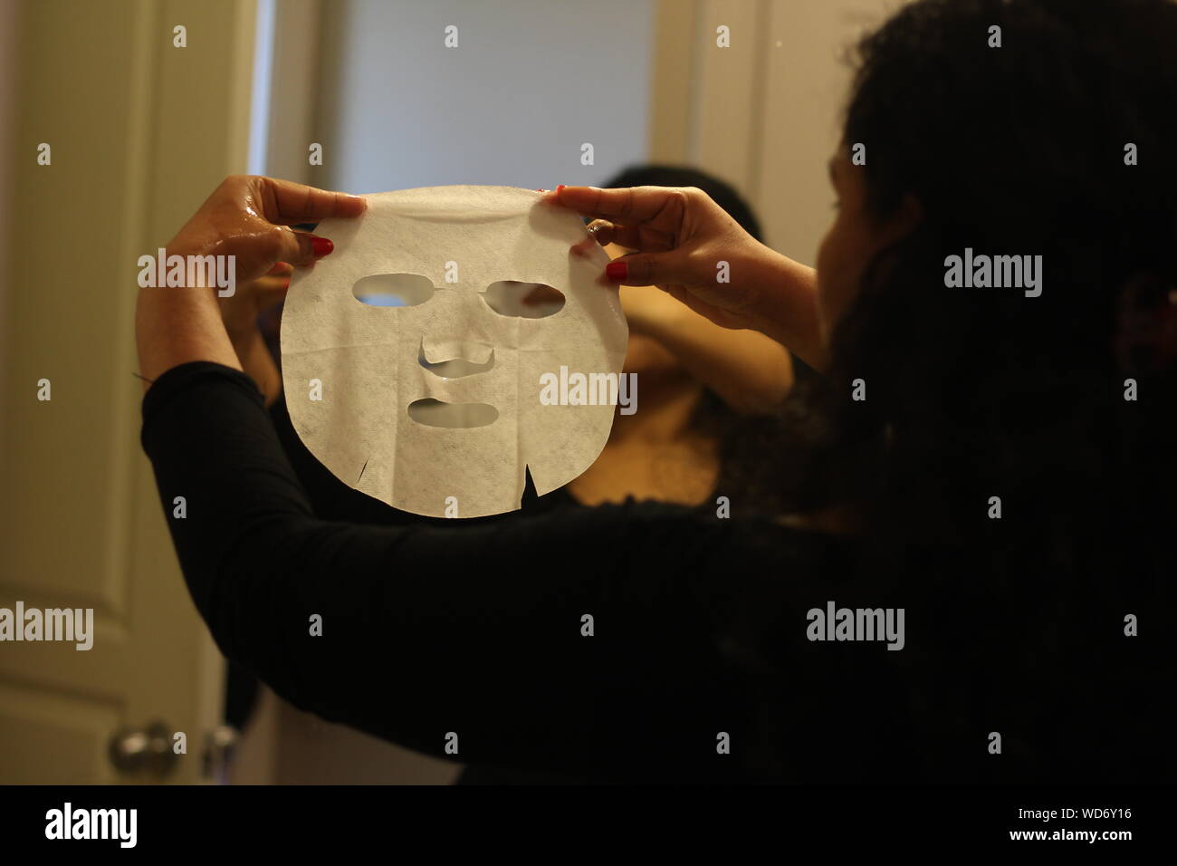 Woman Using Facial Mask At Home Stock Photo