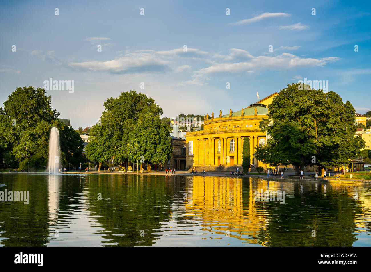 Stuttgart, Germany, August 25, 2019, Historical opera house building reflecting in warm evening sunlight in water of little lake in downtown palace ga Stock Photo