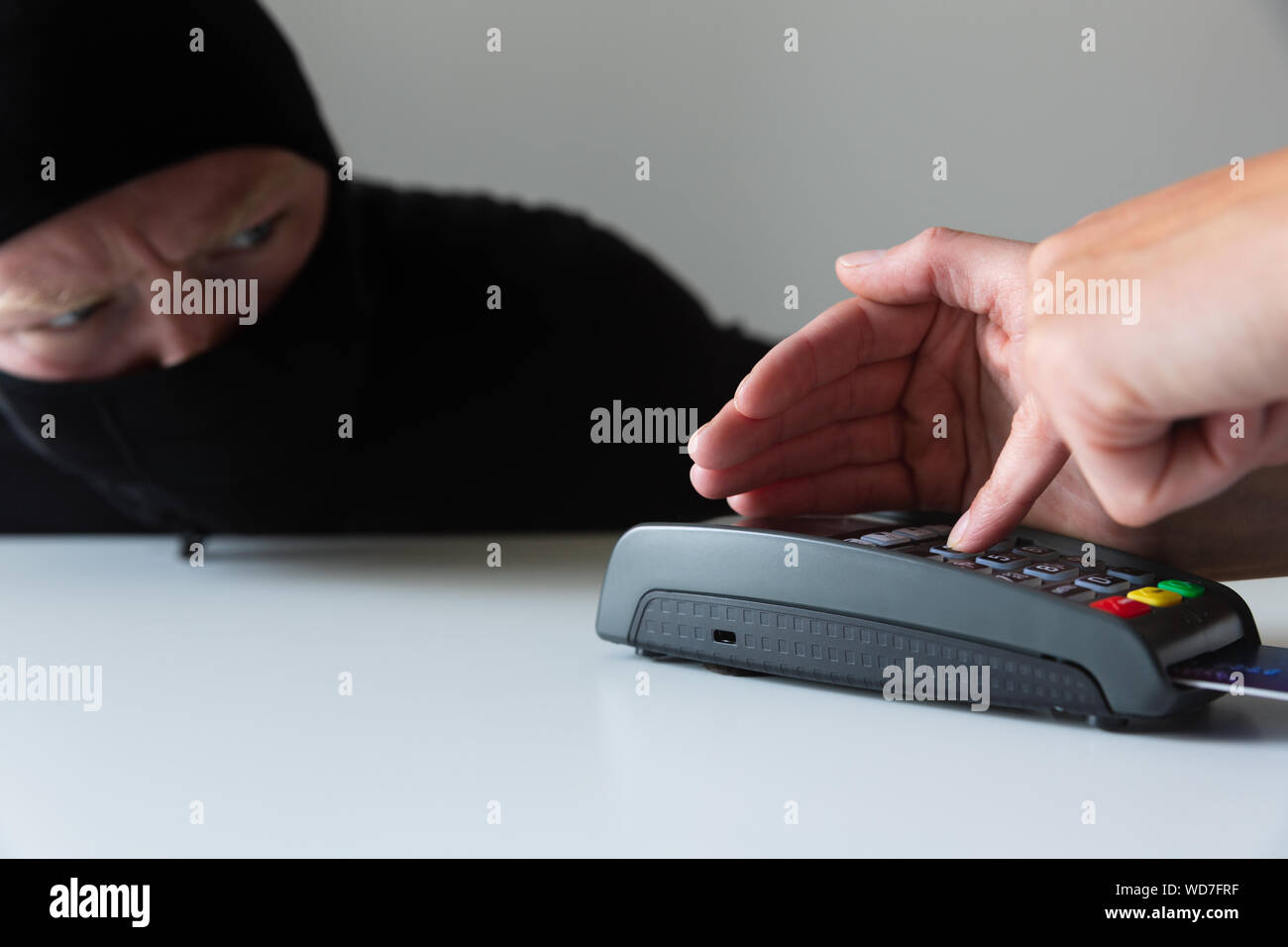 Thief is stealing pin code and identity on payment (pos) terminal machine. Crime concept Stock Photo