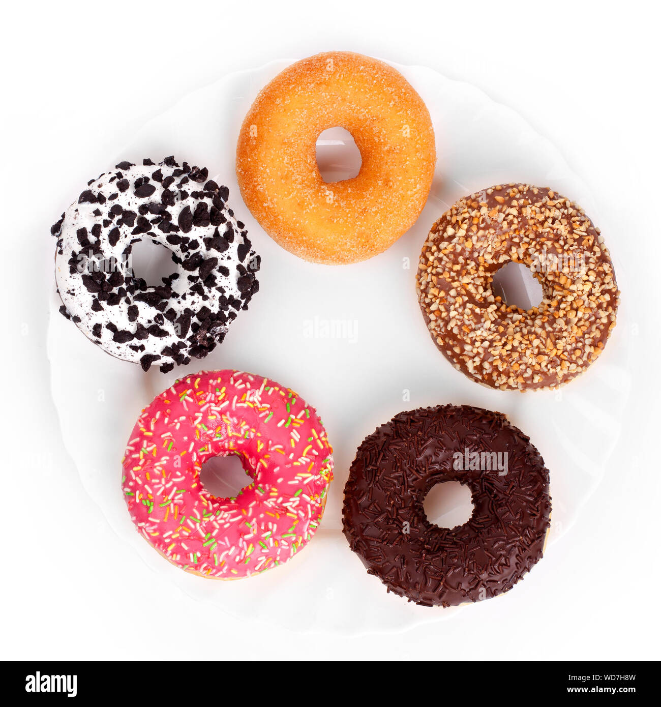 Multicolored donuts on a white plate on a white background top view Stock Photo