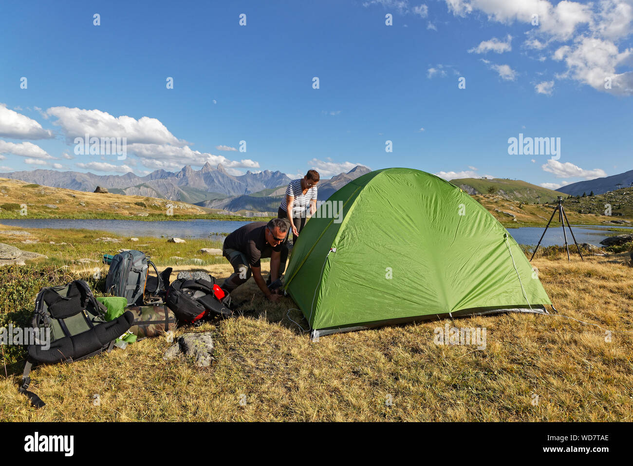 SAINT-SORLIN, FRANCE, August 9, 2019 : Photographers prepare their tent and equipement for a night on a mountain lake shore. Stock Photo