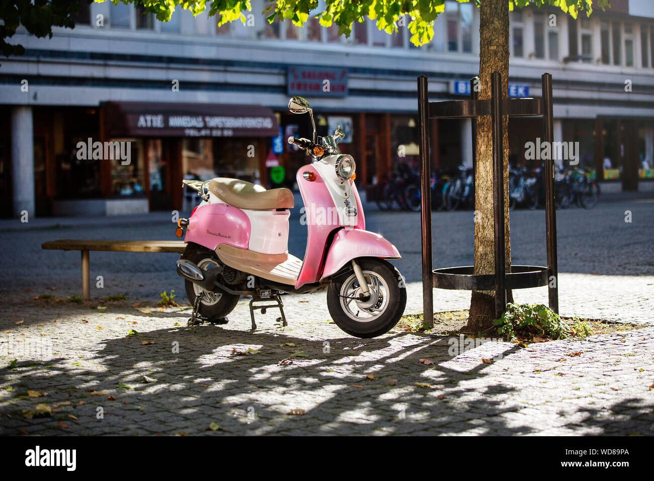 Pink scooter in public square Stock Photo