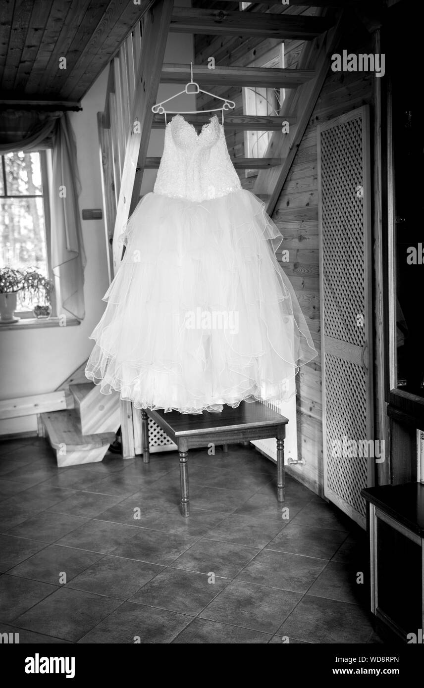Close Up Of Wedding Dress Hanging On Coathanger At Home Stock