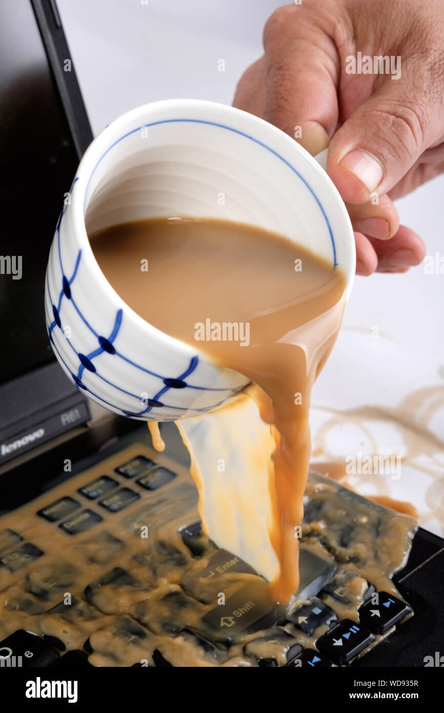 Coffee spilt on open laptop Stock Photo Alamy