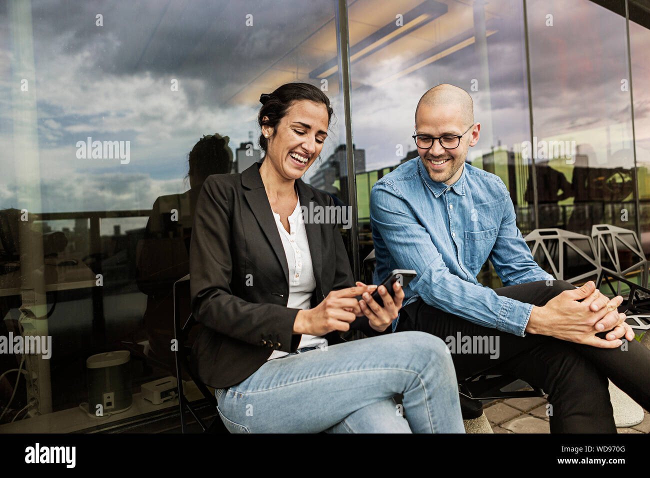 Friends laugh while looking at cell phone Stock Photo