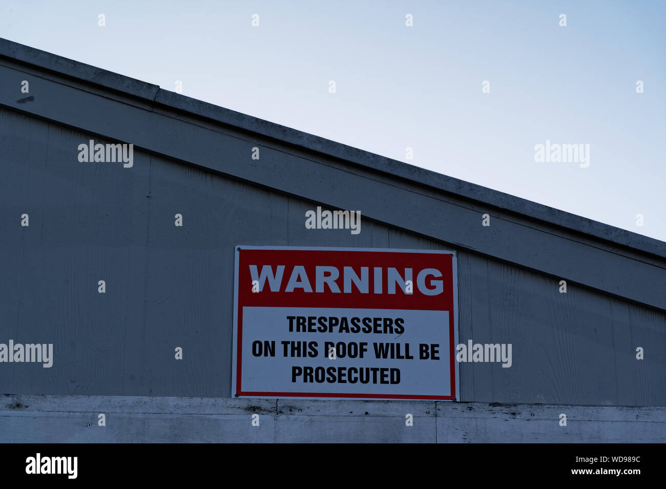 People are warned not to climb on the roof by this sign on a building Stock Photo