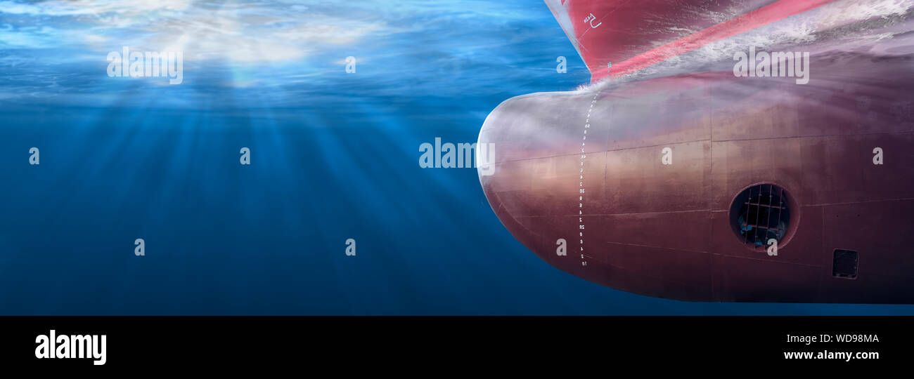 Big cargo ship sailing in the sea to International Shipping container terminal. Close up image detail ships bow, underwater view. Shipping business an Stock Photo