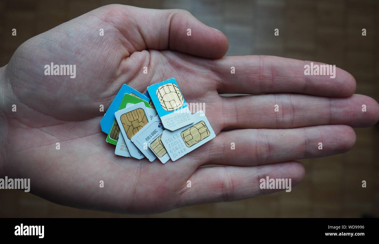 Sim cards various on hand and table Stock Photo