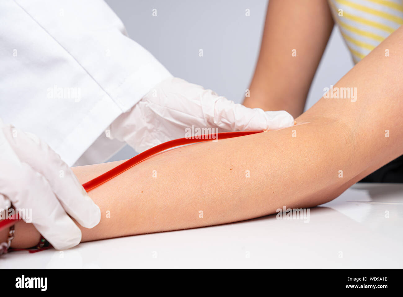 doctor puts a cannula on the arm of a patient Stock Photo