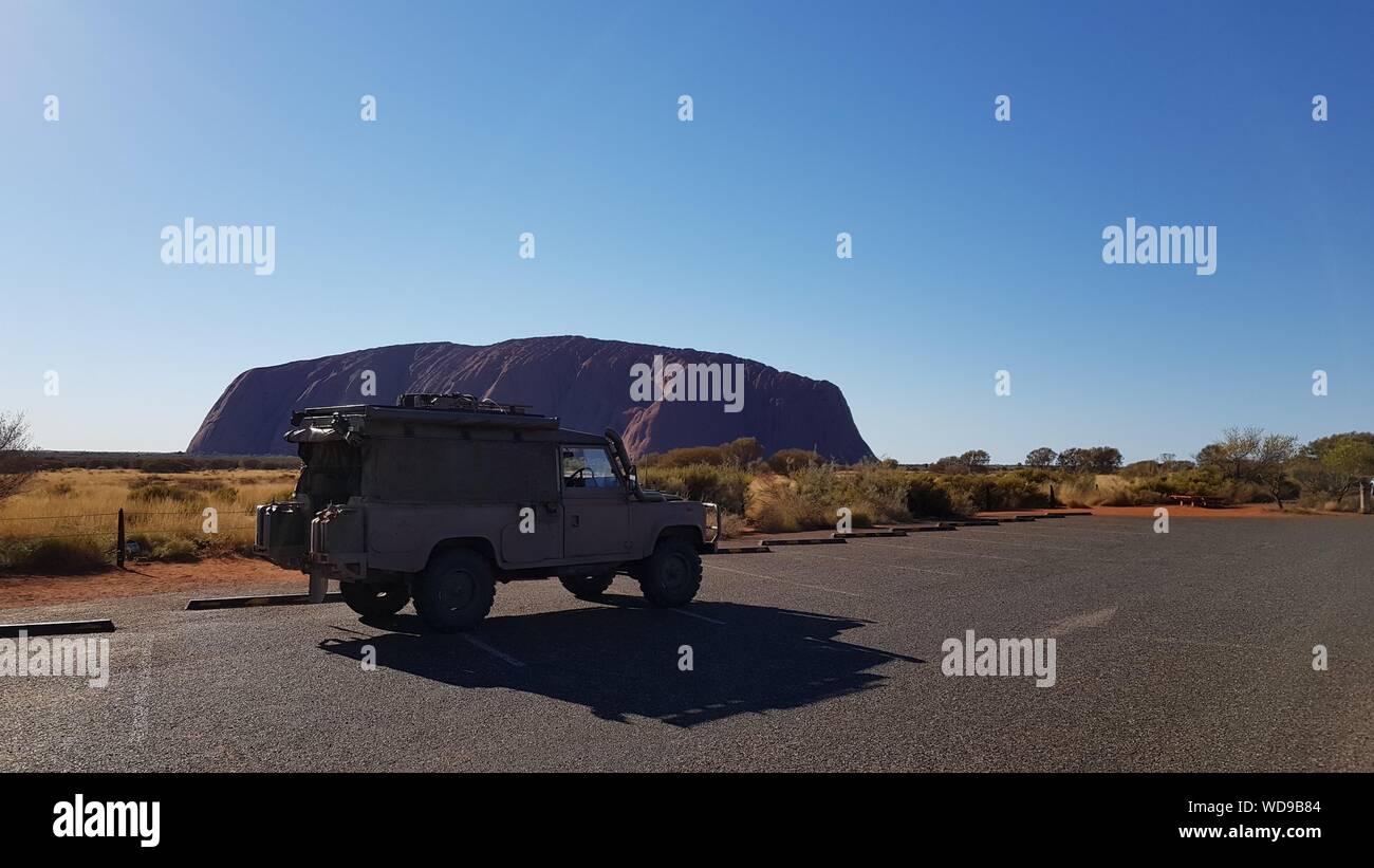 Land Rover Perentie in front of Ayers Rock, Uluru-Kata Tjuta National Park, Northern Territory, Central Australia Stock Photo