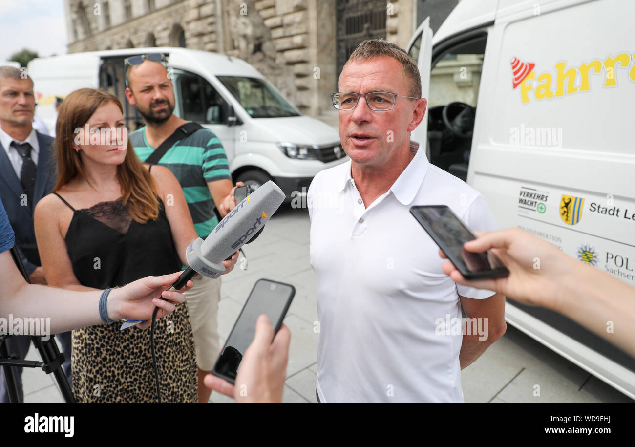 Leipzig, Germany. 28th Aug, 2019. Former football coach Ralf Rangnick talks to journalists after the handover of two mobile traffic schools. Rangnick and his foundation have started a comprehensive cooperation with primary schools in Leipzig. At the start, he handed over two fully equipped VW buses as mobile youth traffic schools to the Leipzig Police Headquarters and the Traffic Guard. In mid-September, the buses will be on their way to the primary schools in Leipzig for the first time. Credit: Jan Woitas/dpa-Zentralbild/dpa/Alamy Live News Stock Photo