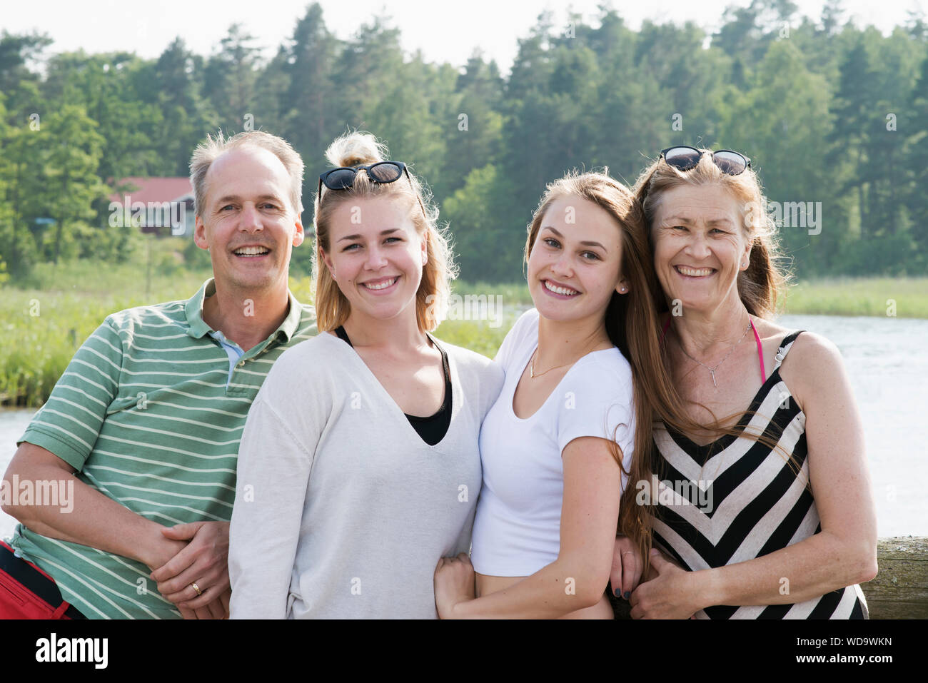 Family with adult offspring in front of lake Stock Photo