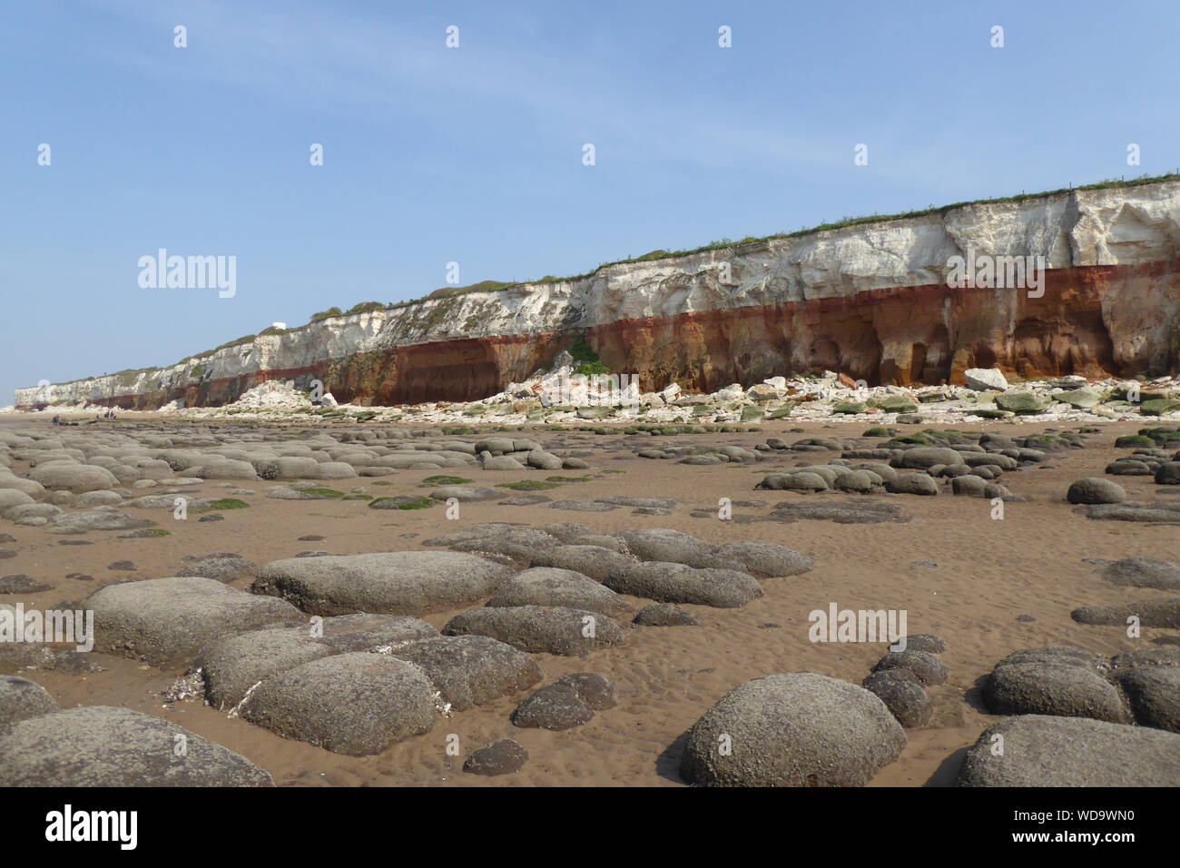 A view of the eroded Hunstanton cliffs on a sunny day with clear, blue skies. Stock Photo