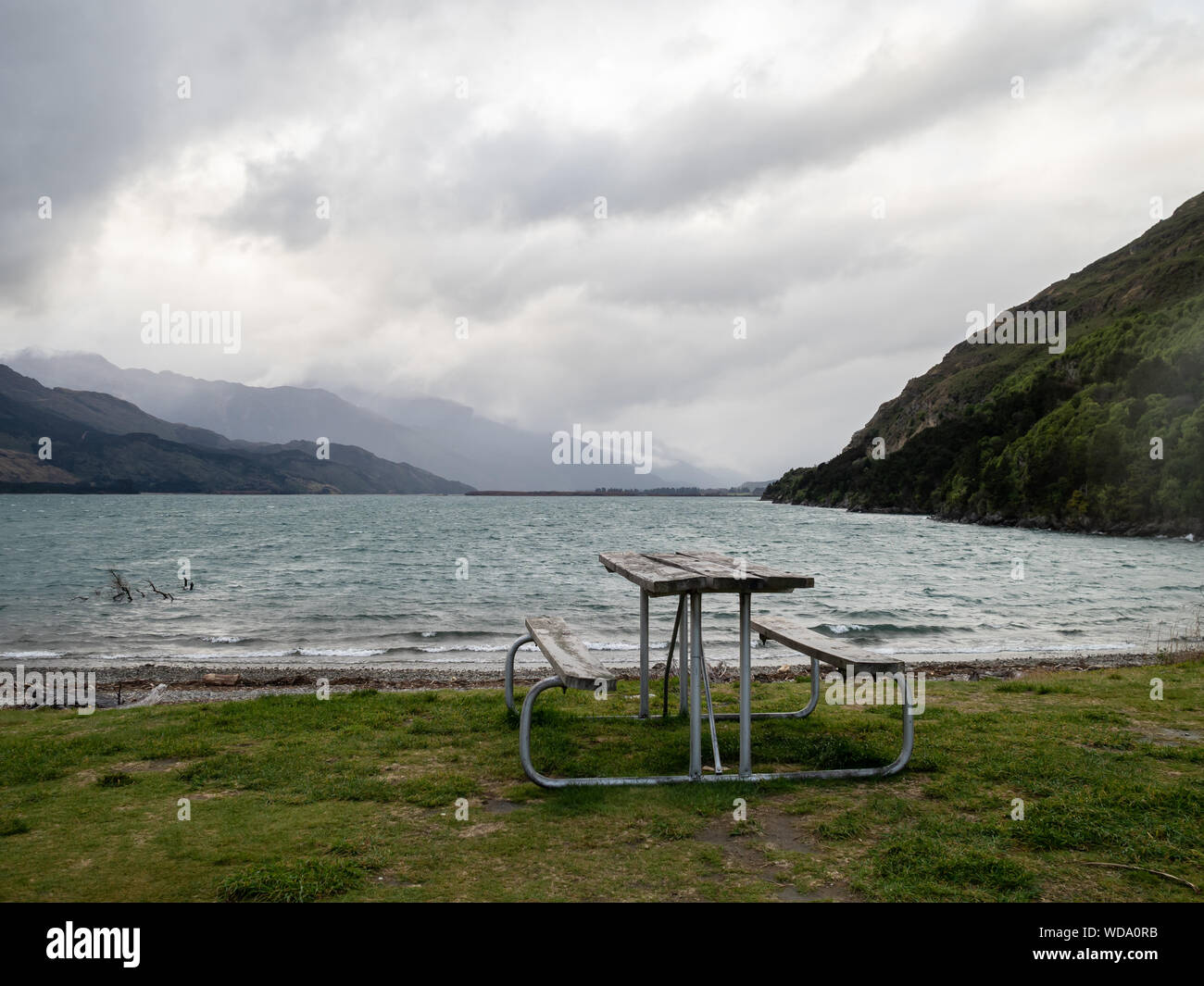Empty picnic bench on the shore of Lake Wanaka in winter, New Zealand Stock Photo
