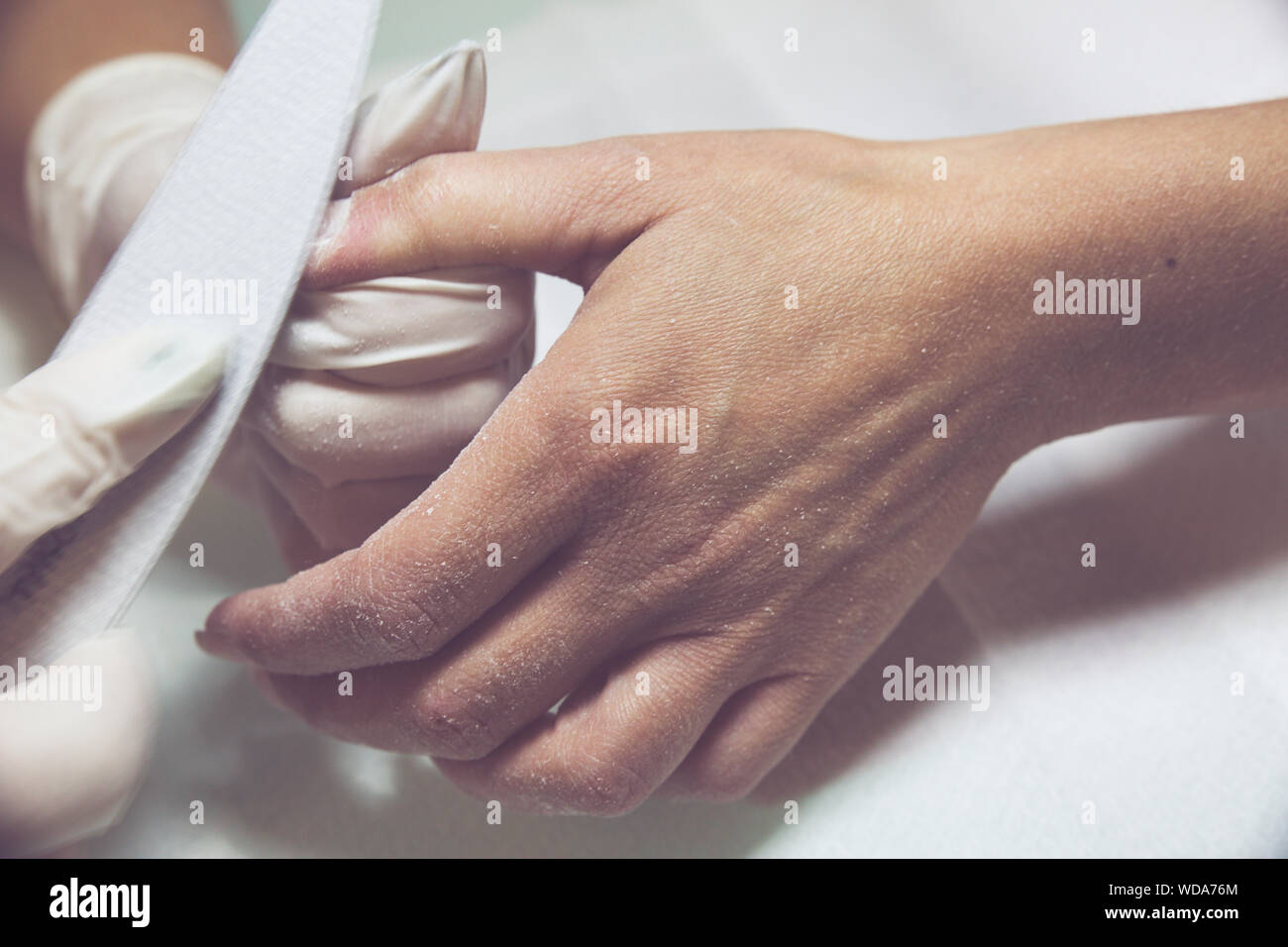 Nail beautician at work while performing the decoration and maintenance of a client's nails Stock Photo