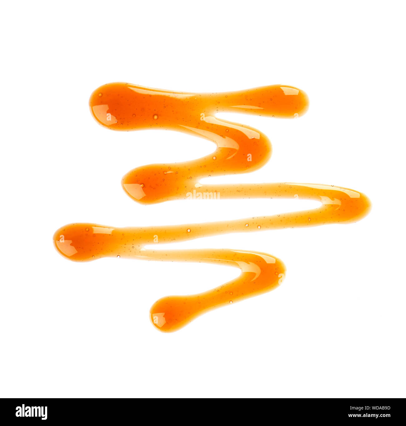 Caramel syrup drizzle isolated on white background. Splashes of sweet