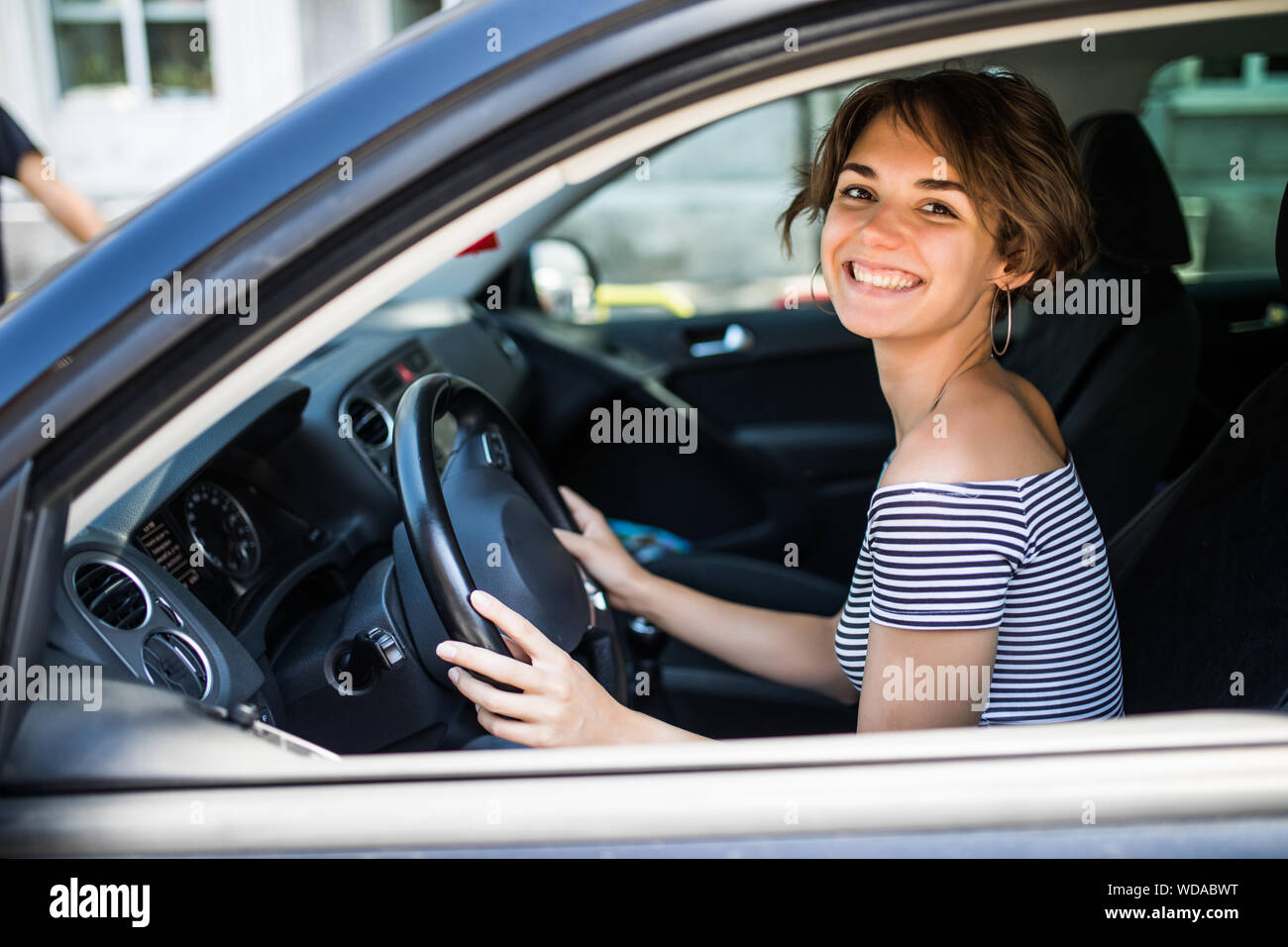 Smiling beautiful brunette woman driving a car Stock Photo - Alamy