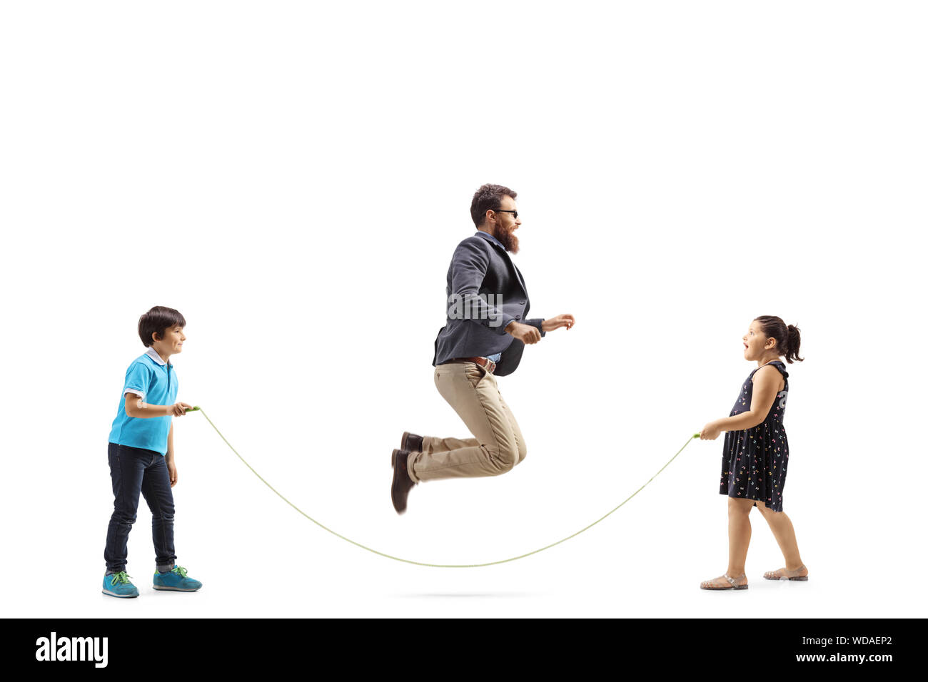 Full length profile shot of children holding a rope and a man skipping isolated on white background Stock Photo