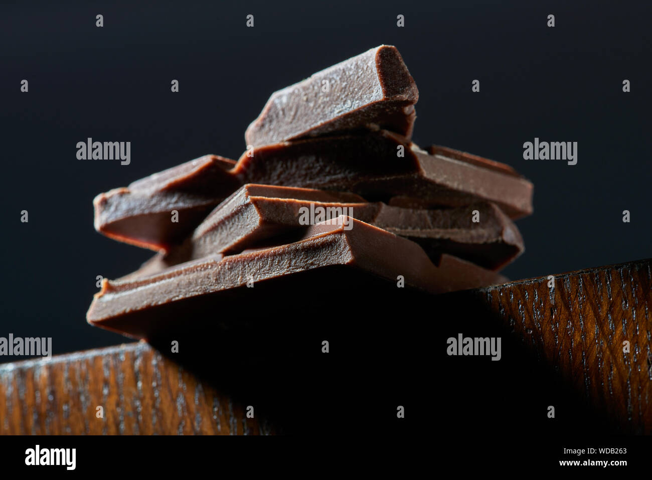 Chocolate chunks viewed from below. Sweet food photo concept. Dark background. Horizontal image Stock Photo