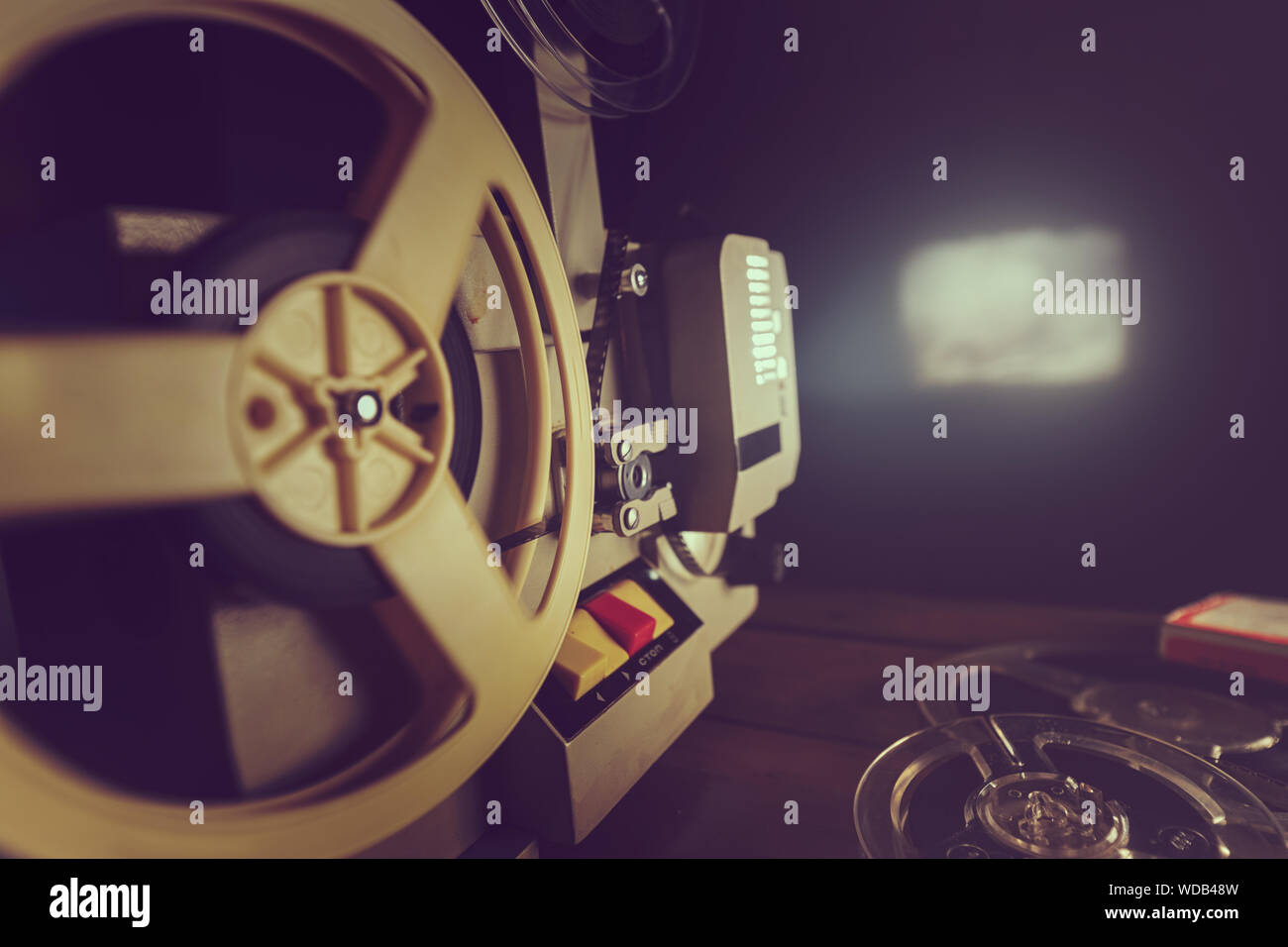 retro 8mm film projector playing old movie on the wall in dark room