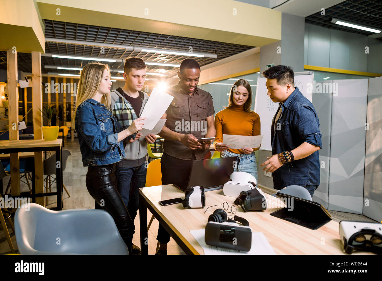 Young people software programmers testing a new apps with 3d virtual reality glasses, laptops and tablets in office Stock Photo