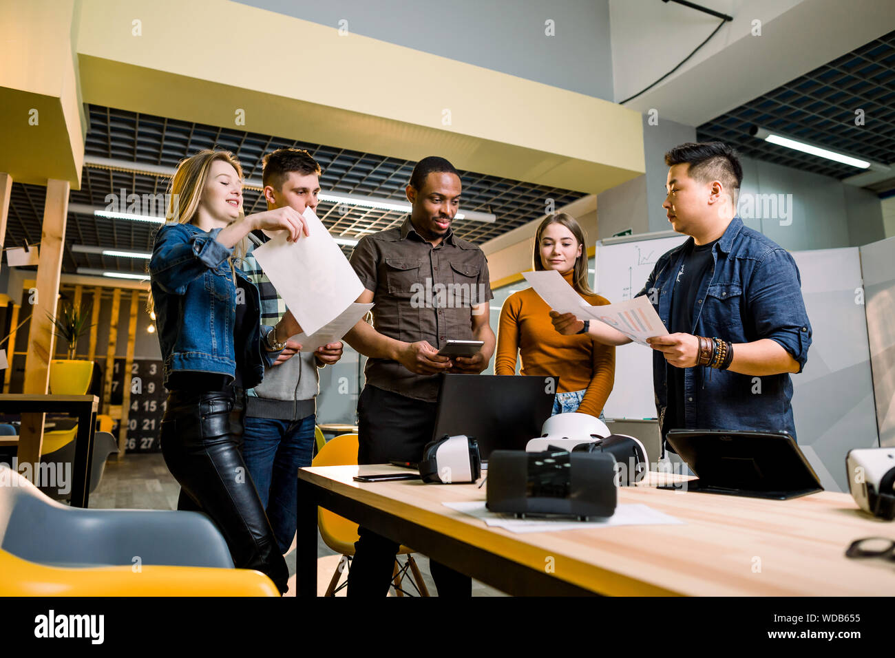Young people software programmers testing a new apps with 3d virtual reality glasses, laptops and tablets in office Stock Photo