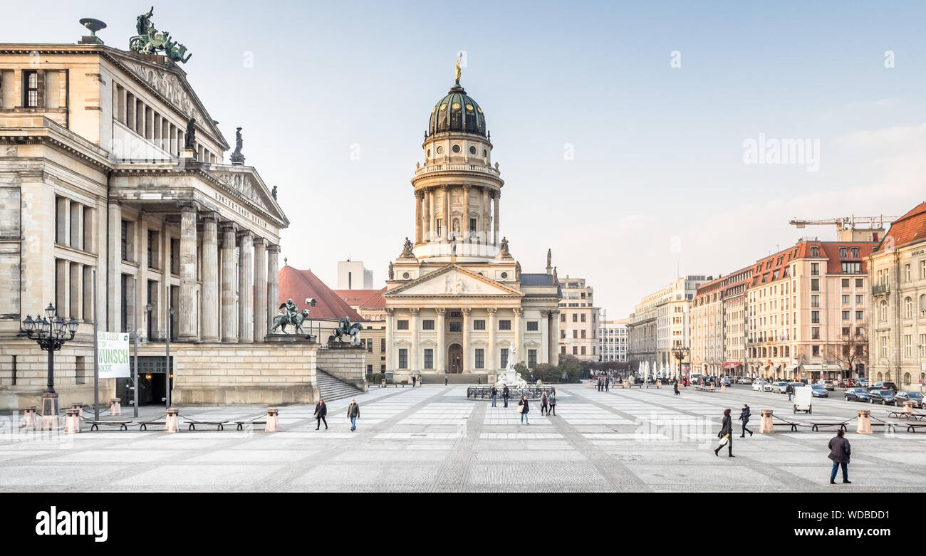 People Walking By French Cathedral At Gendarmenmarkt Stock Photo