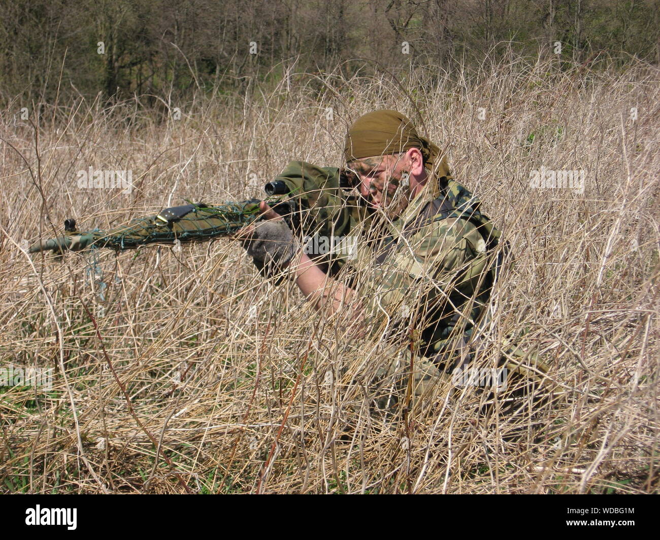 Sniped Aiming With Rifle At Grassy Field Stock Photo