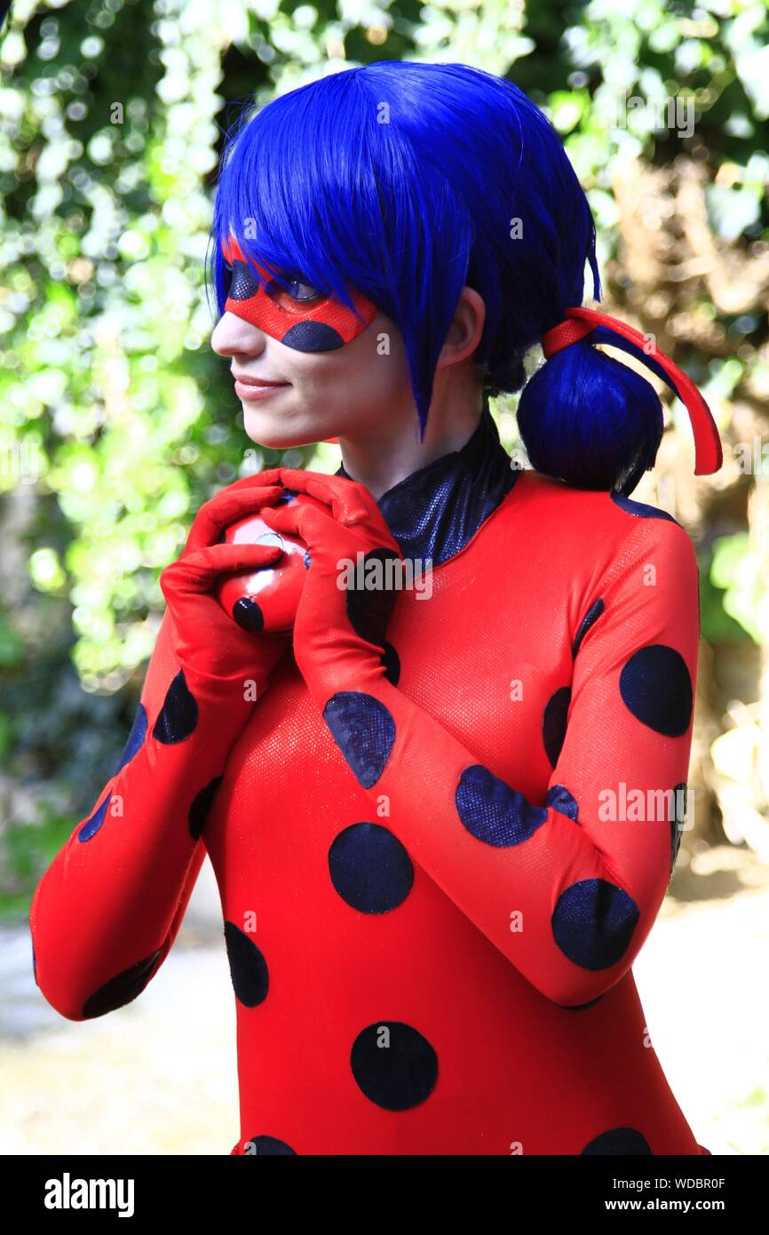 Young Woman With Blue Hair Wearing Red Costume Looking Away While Standing  Outdoors Stock Photo - Alamy