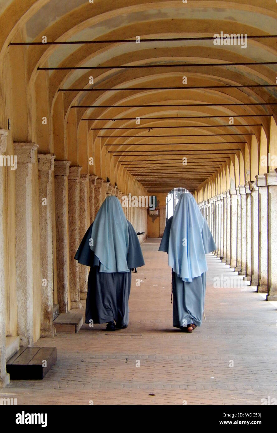 Rear View Of Nuns In Corridor Stock Photo