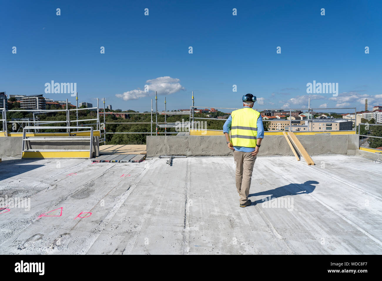 Construction worker on roof of incomplete building Stock Photo