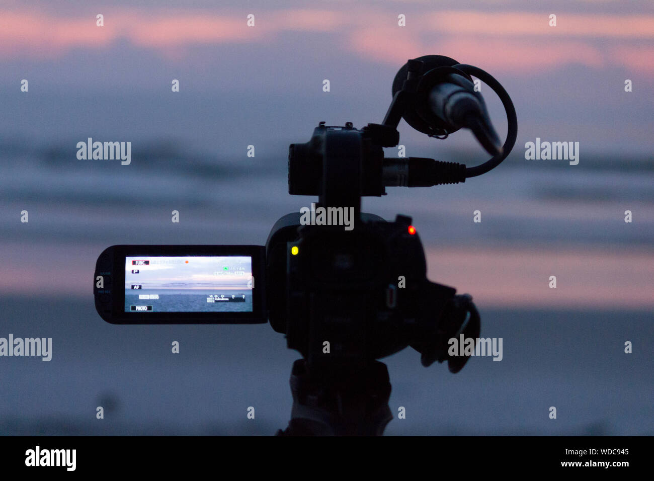 Close-up Of Home Video Camera At Beach During Sunset Stock Photo