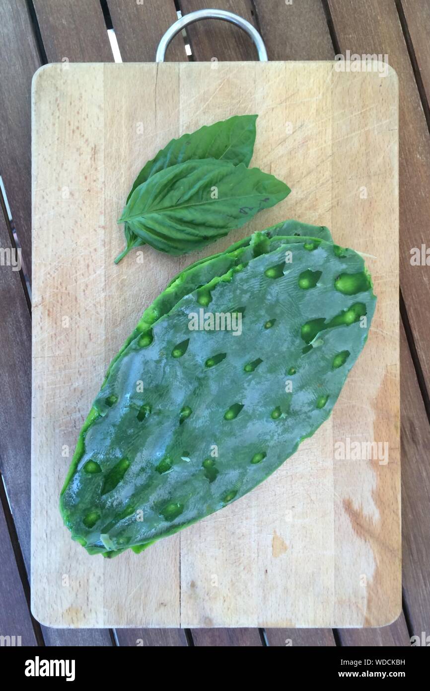 High Angle View Of Nopal And Leaves On Cutting Board Stock Photo