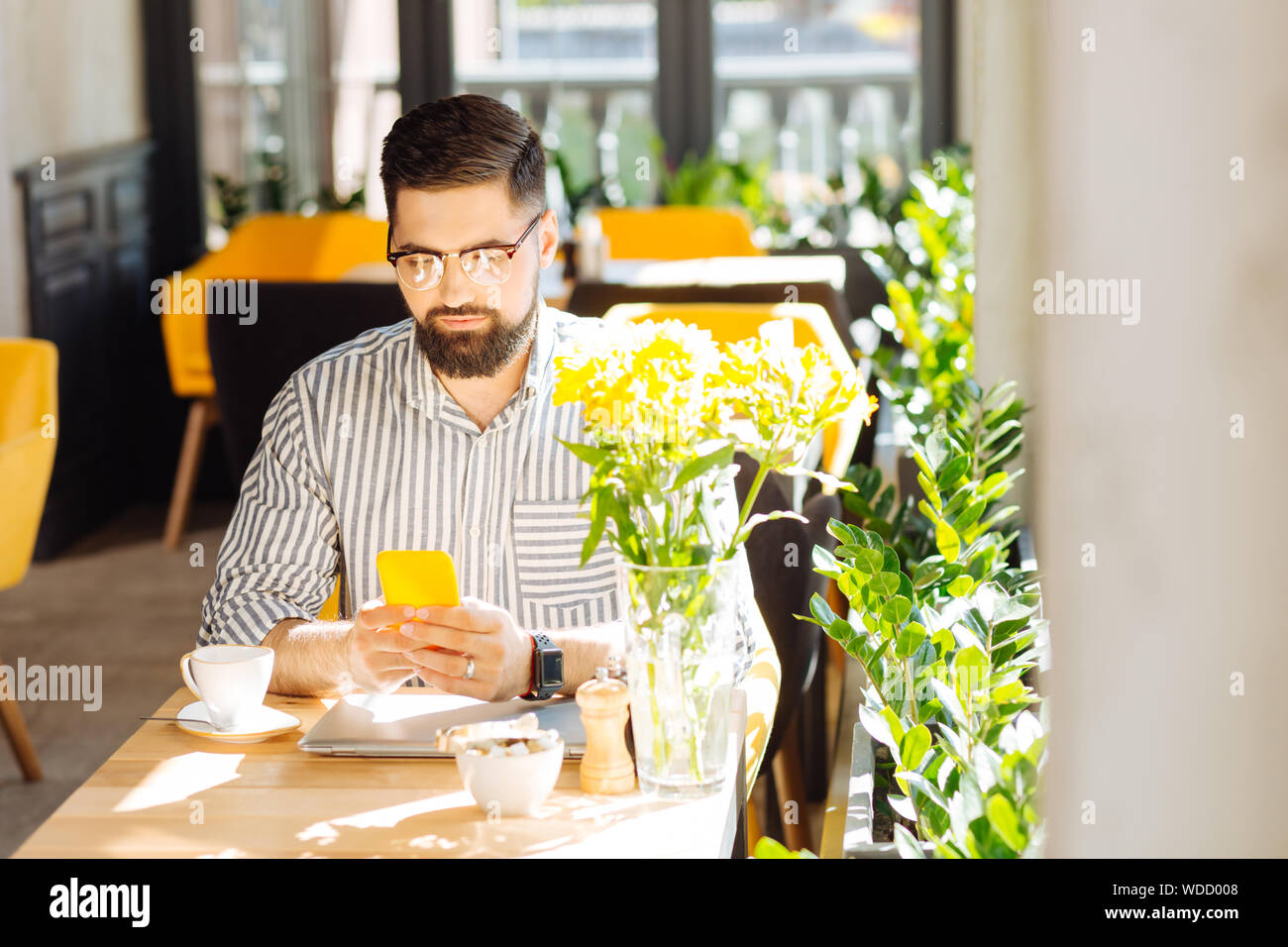 Nice good looking man using his modern smartphone Stock Photo
