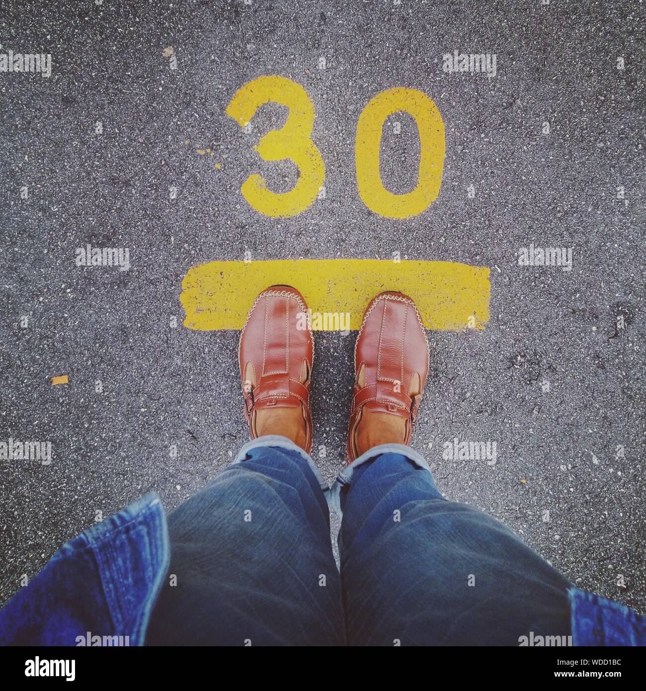 Low Section Of Person Standing In Front Of Number 30 On Street Stock 