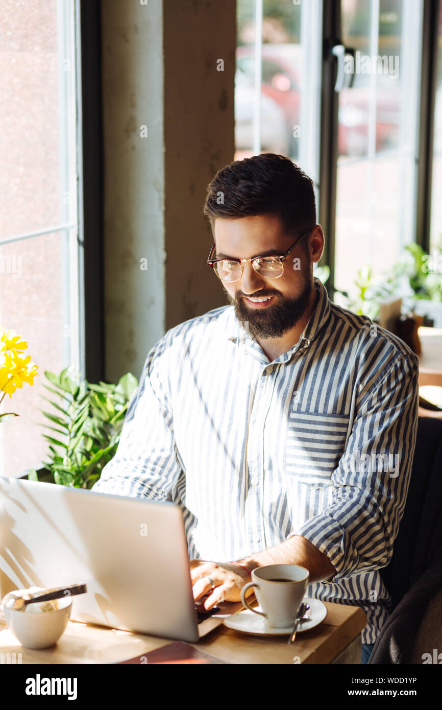 Delighted positive man looking at the keyboard Stock Photo