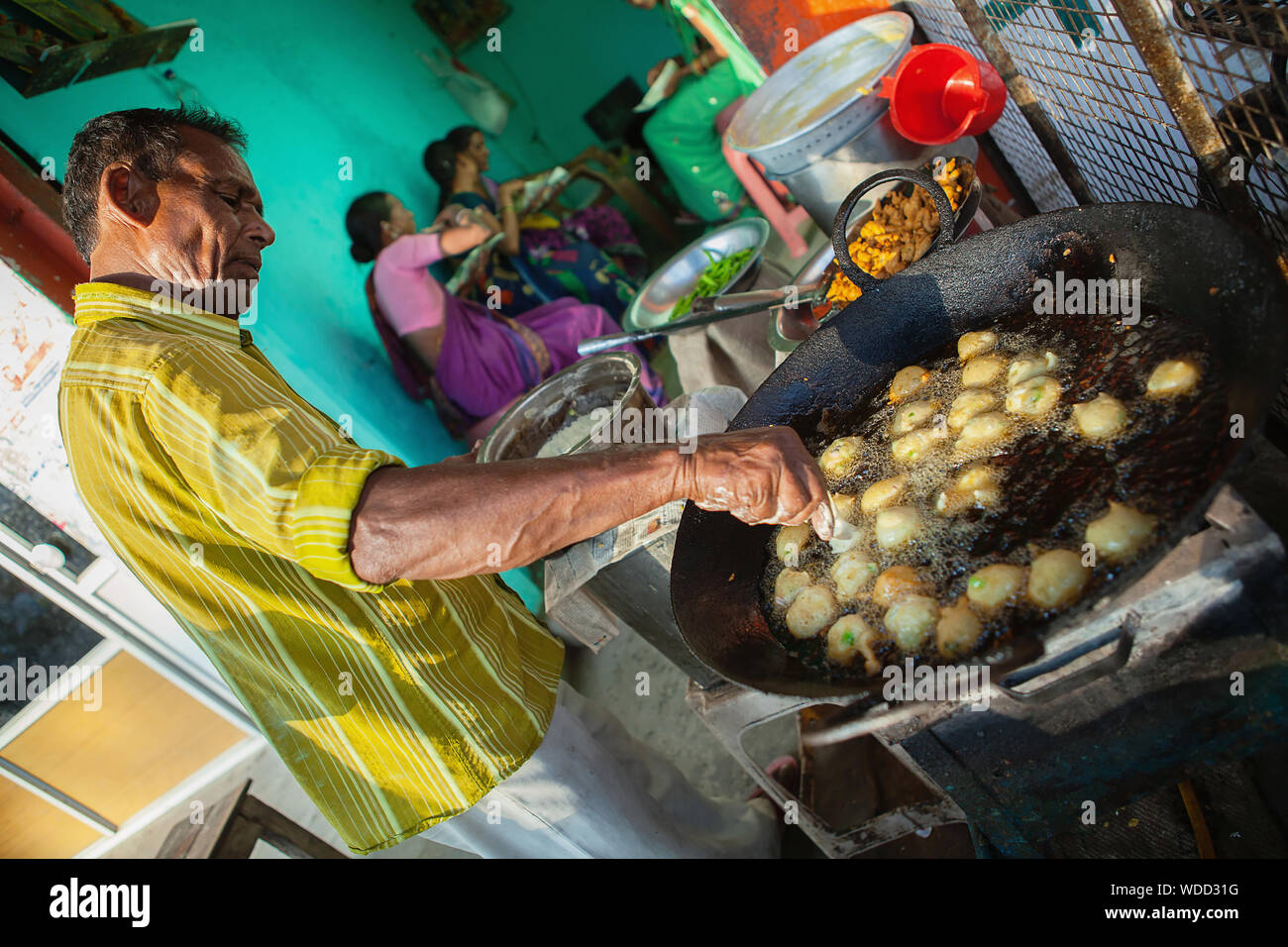 India, Andhra Pradesh, Armoor, Food hotel vendor frying chilli bhajis. Stock Photo