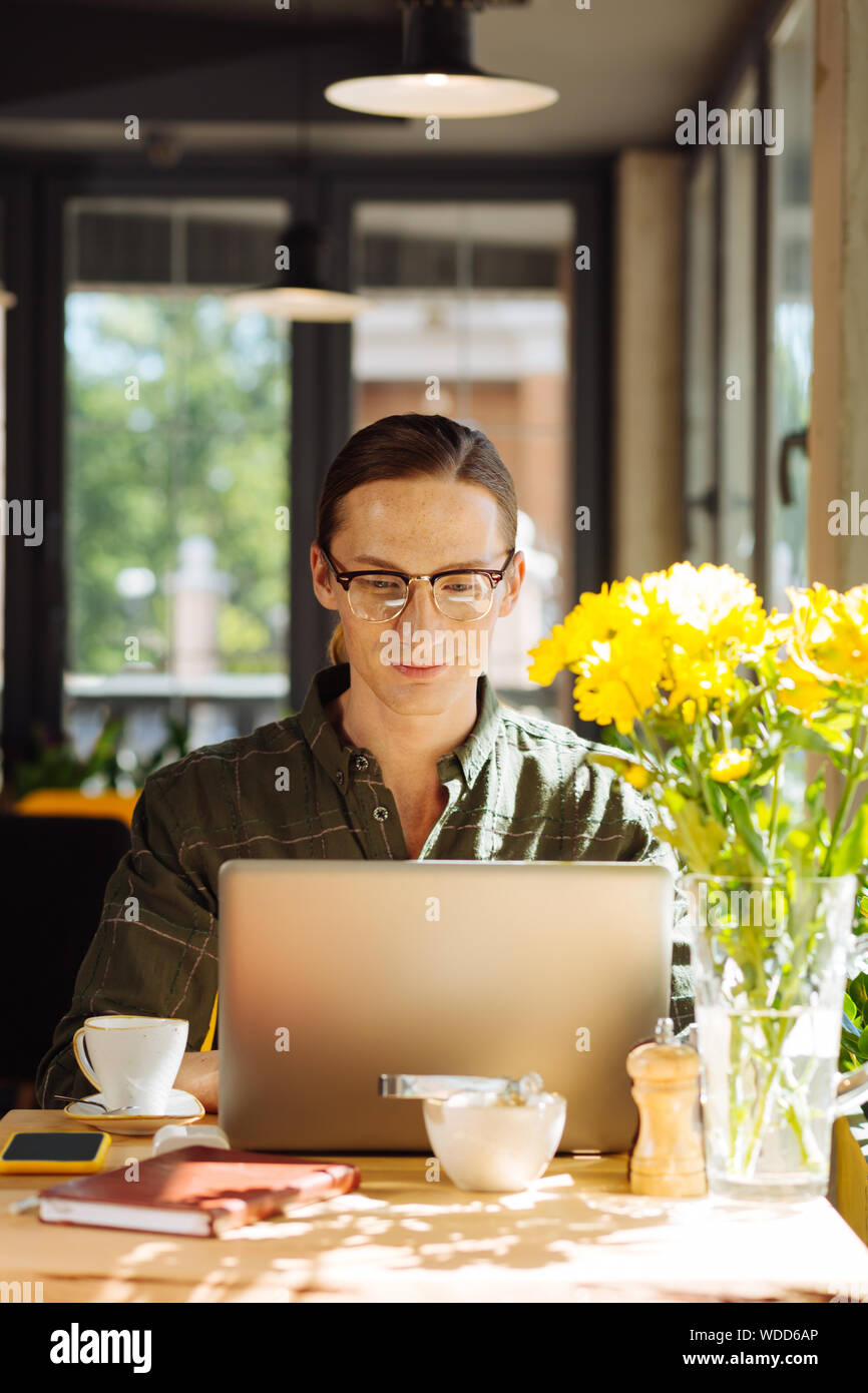 Positive nice man working remotely on his laptop Stock Photo