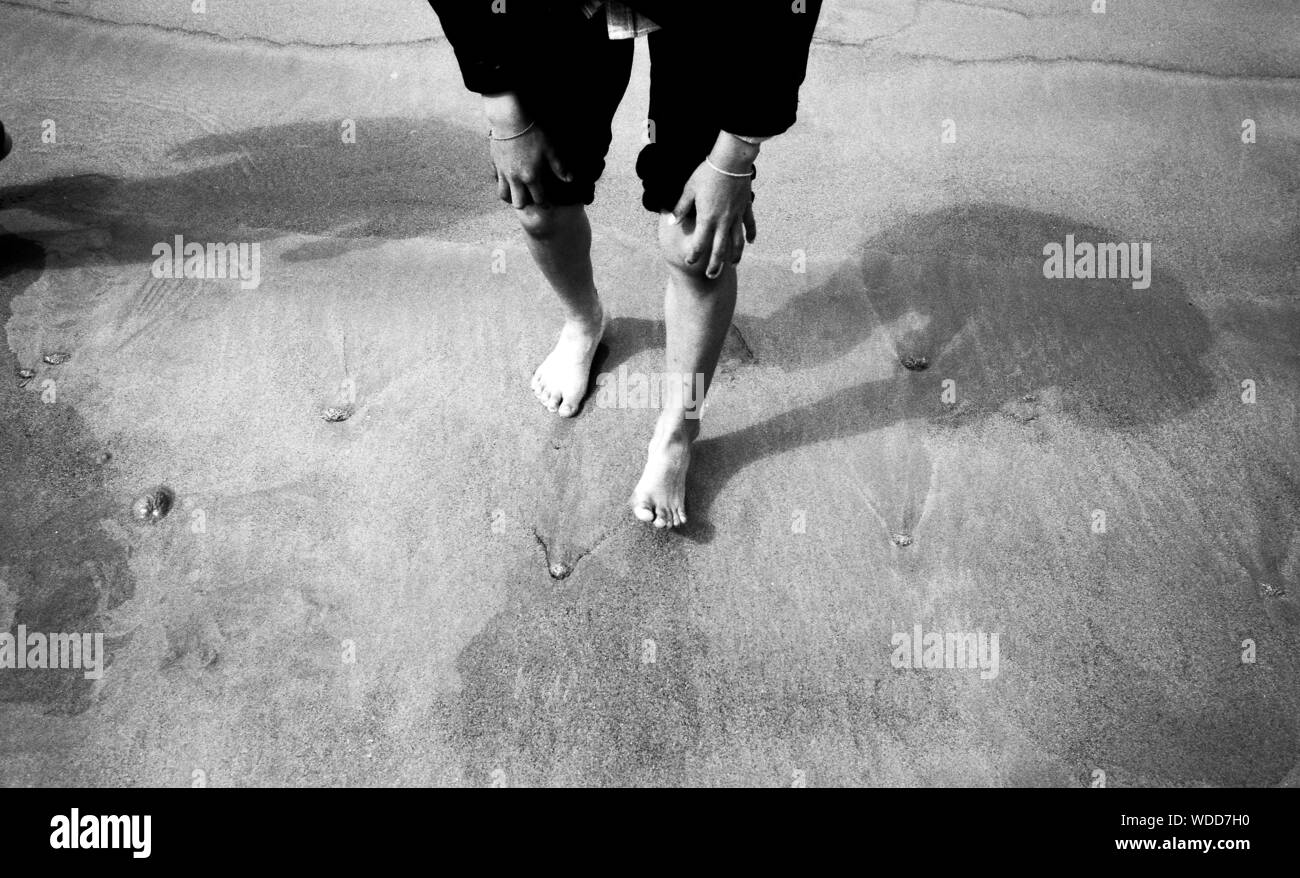 Hand resting on leg sand Black and White Stock Photos & Images Alamy